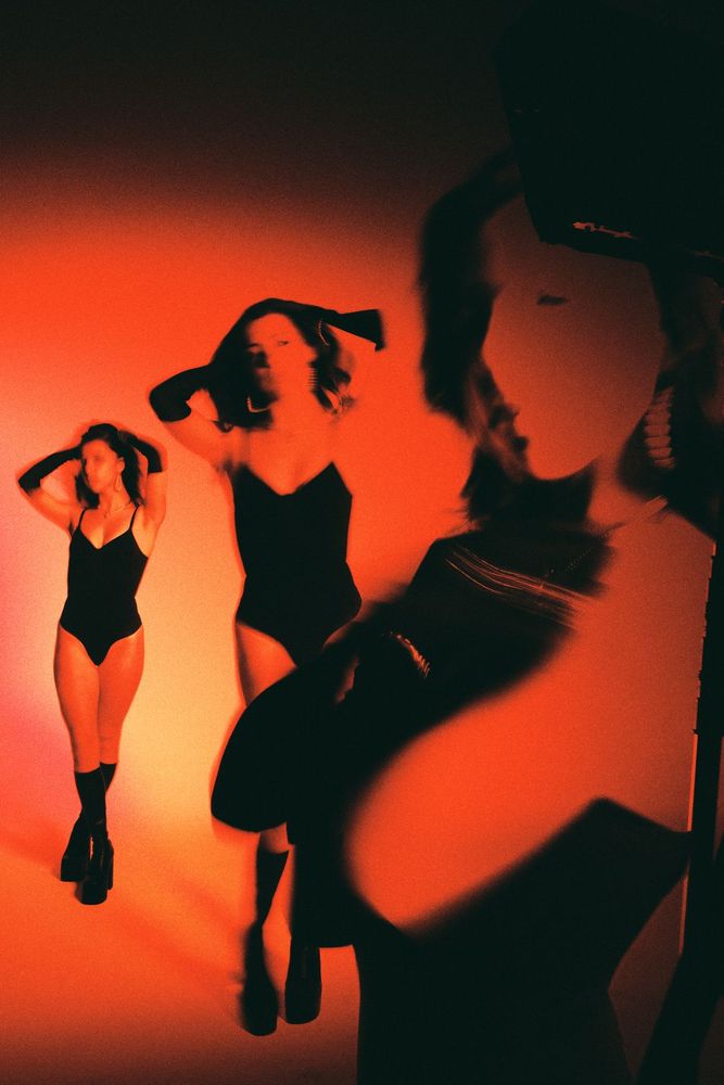 Three dancers in red and orange light
